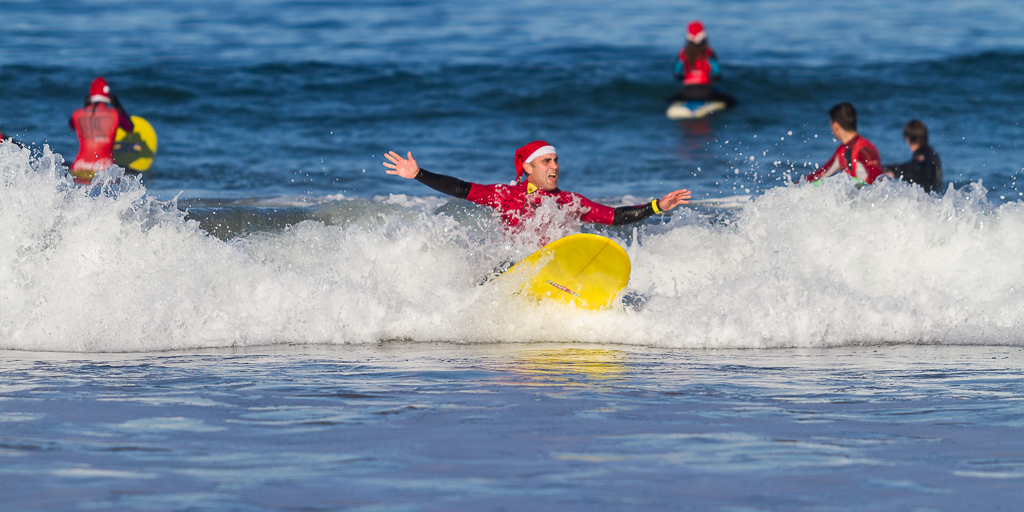 Papa noeles surferos en la playa de patos